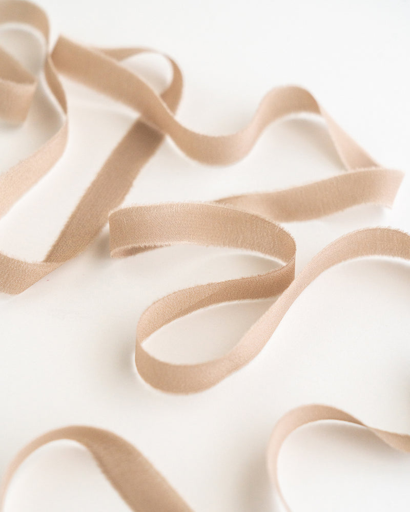 Tono + co Silk Ribbon Trim in Fawn. Perfect for stationary styling, boutonnieres, and detail work. Find your inspiration through color and silk. Lovingly hand-dyed in Santa Ana, California and available in 24 signature colors. Check out our website for more styling, flat-lay, and color tips.