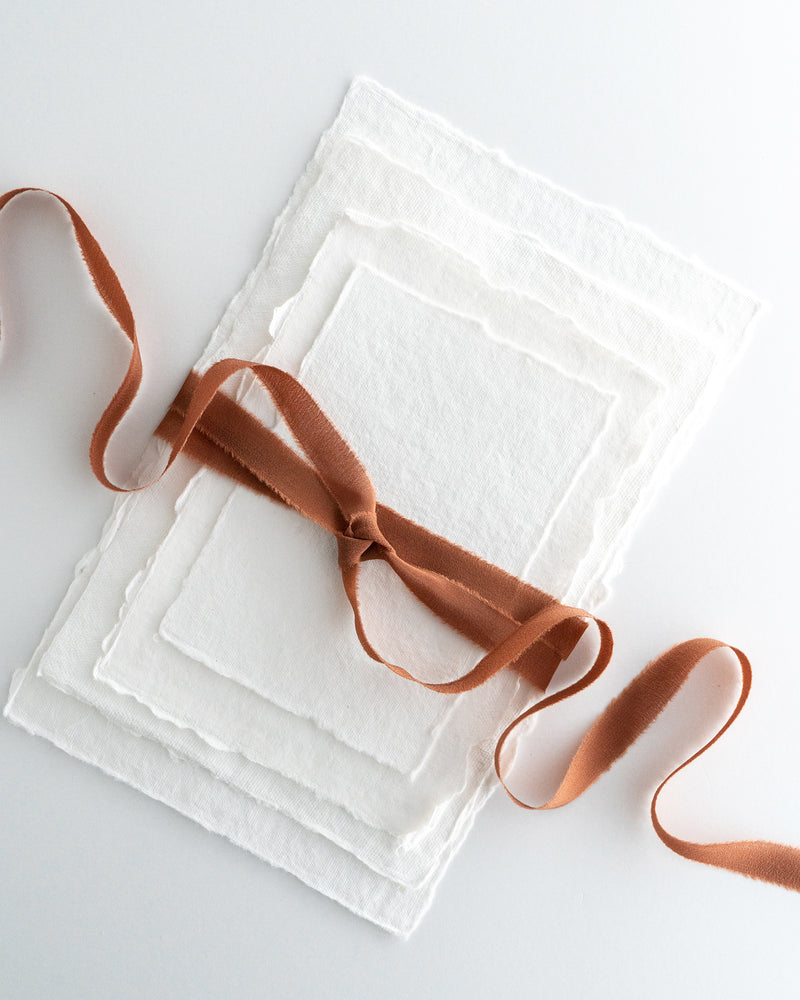 Tono + co Silk Ribbon Trim in Copper. Perfect for stationary styling, boutonnieres, and detail work. Find your inspiration through color and silk. Lovingly hand-dyed in Santa Ana, California and available in 24 signature colors. Check out our website for more styling, flat-lay, and color tips.