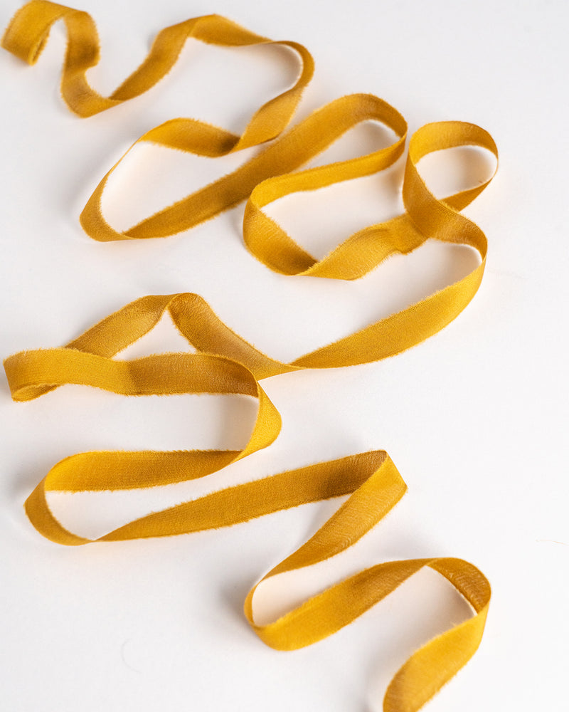 Tono + co Silk Ribbon Trim in Oro. Perfect for stationary styling, boutonnieres, and detail work. Find your inspiration through color and silk. Lovingly hand-dyed in Santa Ana, California and available in 24 signature colors. Check out our website for more styling, flat-lay, and color tips.